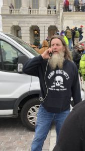 This image portrays the man described in the text as wearing a "Camp Aushwitz" shirt during the January 6 riots at the Capitol Building.